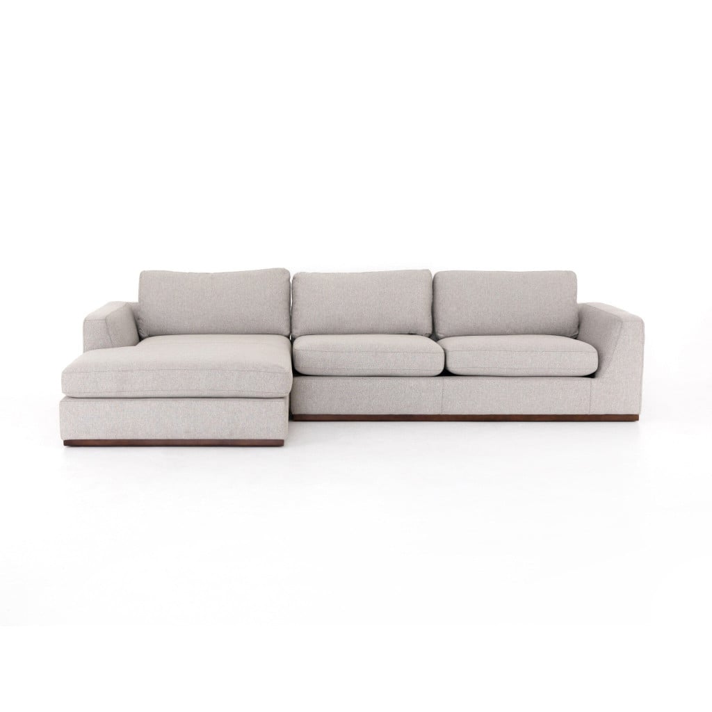 Front view of the Colt 2-piece sectional with left chaise in Aldred Silver textured fabric | Three-quarter view of the Colt chaise sectional showing the 129-inch span and plinth base | Side view of the Colt sectional highlighting the left-arm-facing chaise | Room scene with the Colt silver chaise sectional in a living room setting | Close-up of the Aldred Silver poly-linen upholstery texture | Rear view of the Colt 2-piece chaise sectional | Detail of the Colt's boxed back cushions with removable casings | Close-up of the Colt's interlocking clip between the two sectional pieces | Detail of the Colt's wrapped plinth base | Close-up of the chaise cushion and flared side profile | Detail view of the Colt's cushion seams and tailored finish
