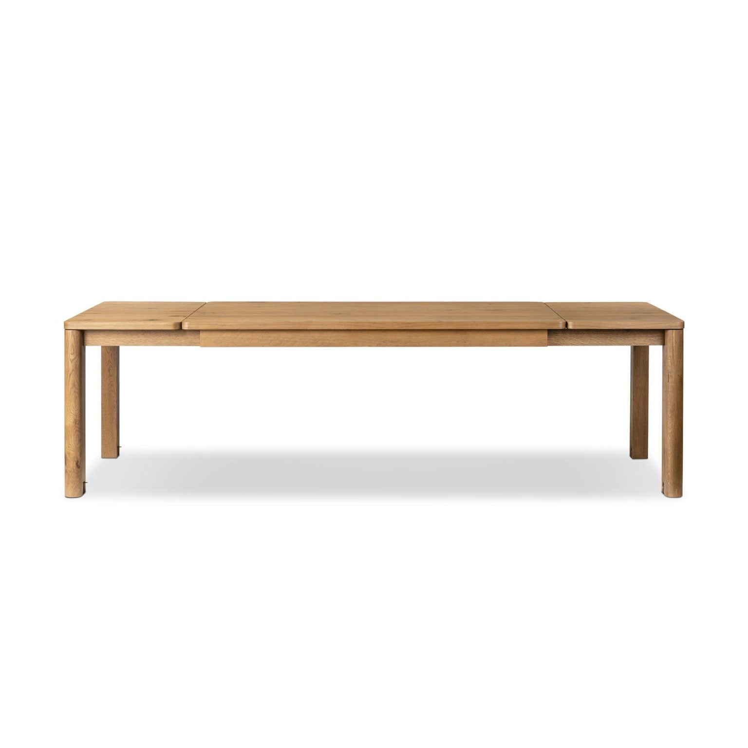 Front view of the Noeline extension dining table in resawn worn oak, closed at 65 inches | Three-quarter view of the Noeline table showing the light oak finish | Side profile of the Noeline dining table with iron and brass accents | Close-up of the resawn oak veneer grain in worn finish | Detail of the Noeline's mortise-and-tenon joinery | The Noeline table open at 105 inches with leaves extended | Top-down view of the Noeline's oak tabletop surface | Close-up of the brass accent details on the Noeline table | Detail of the lockable caster wheels | Room scene with the Noeline extension table in a dining room