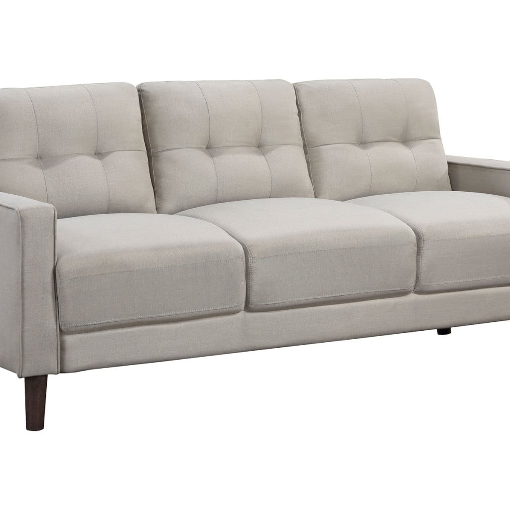 Bowen beige performance fabric track-arm sofa in beige polyester fabric, angled view showing tapered brown legs