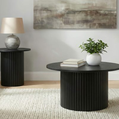 Hamlyn round fluted end table in black wood, styled beside an armchair