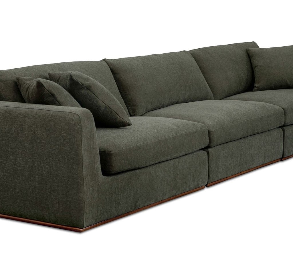 Rue modular sofa in deep green polyester fabric, diagonal silhouette view showing the low profile